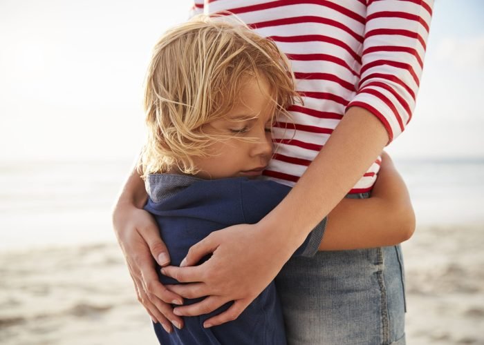 close-up-of-mother-hugging-son-on-summer-beach-vac-2022-03-30-20-23-36-utc (1)